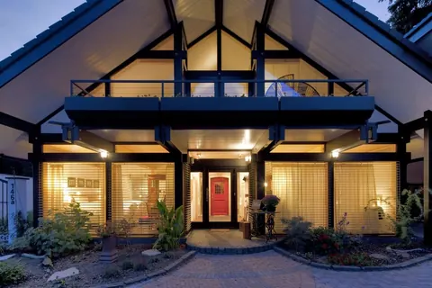 Contemporary villa with glazed gable, lit at dusk