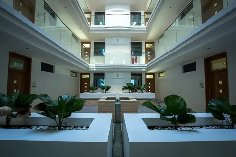 Bright atrium with planters and white balconies